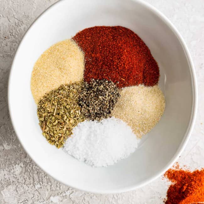 a white bowl filled with spices and seasonings.