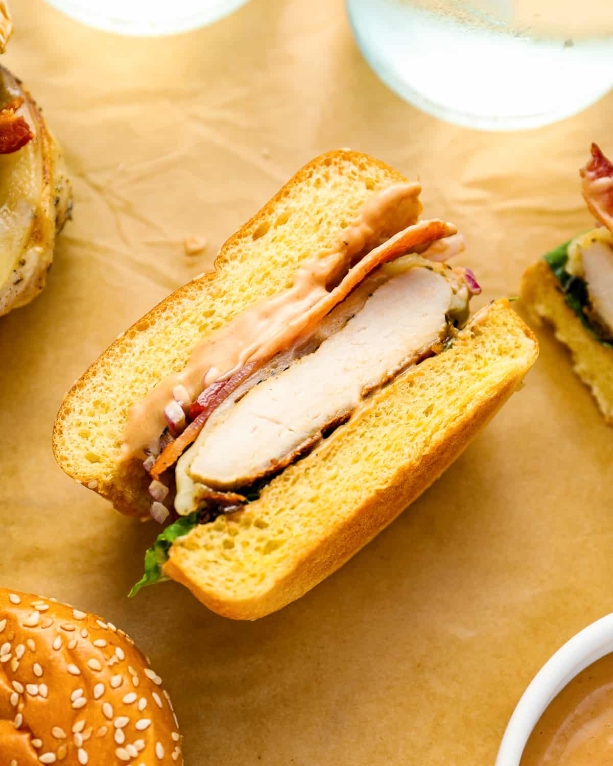 a halved grilled chicken sandwich laying face up to show the layers.