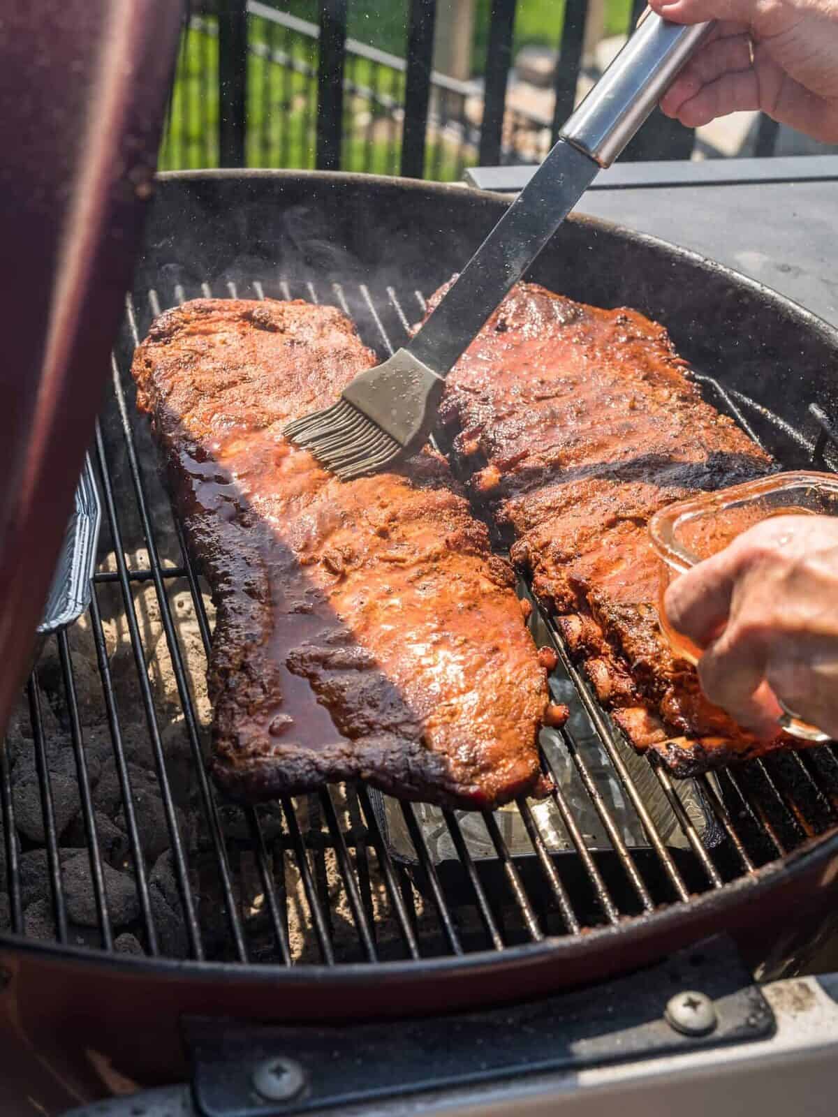St.Louis Ribs being mopped on a grill