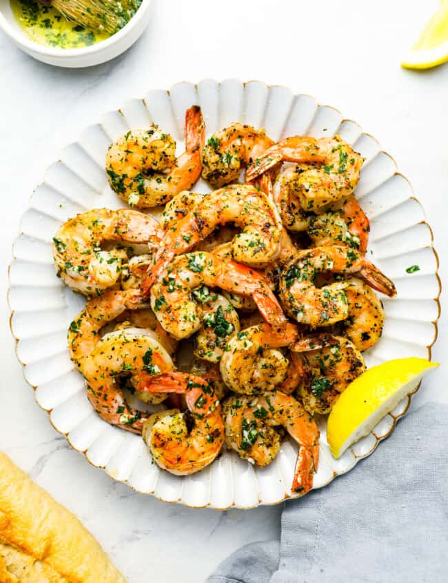 overhead view of grilled shrimp on a white plate.