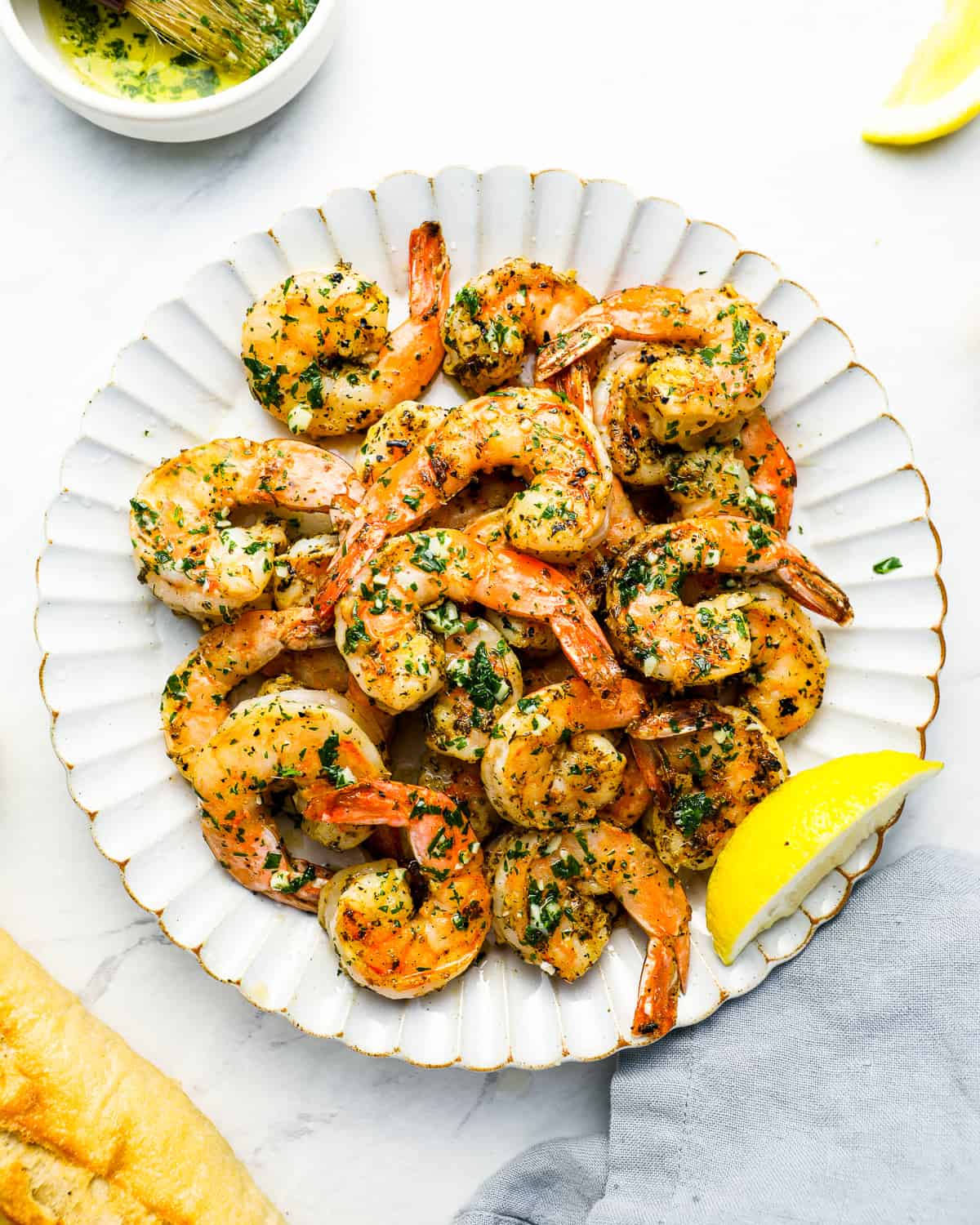 overhead view of grilled shrimp on a white plate.