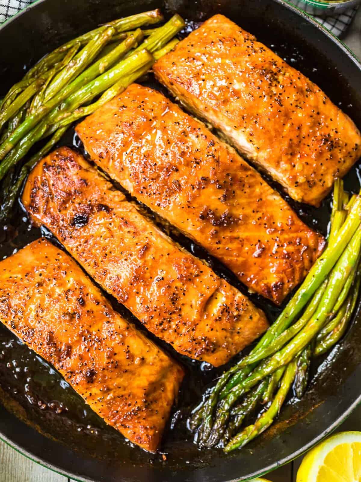 up close honey garlic salmon with asparagus in skillet