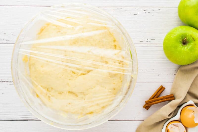 a baking dish with apples and cinnamon next to it.