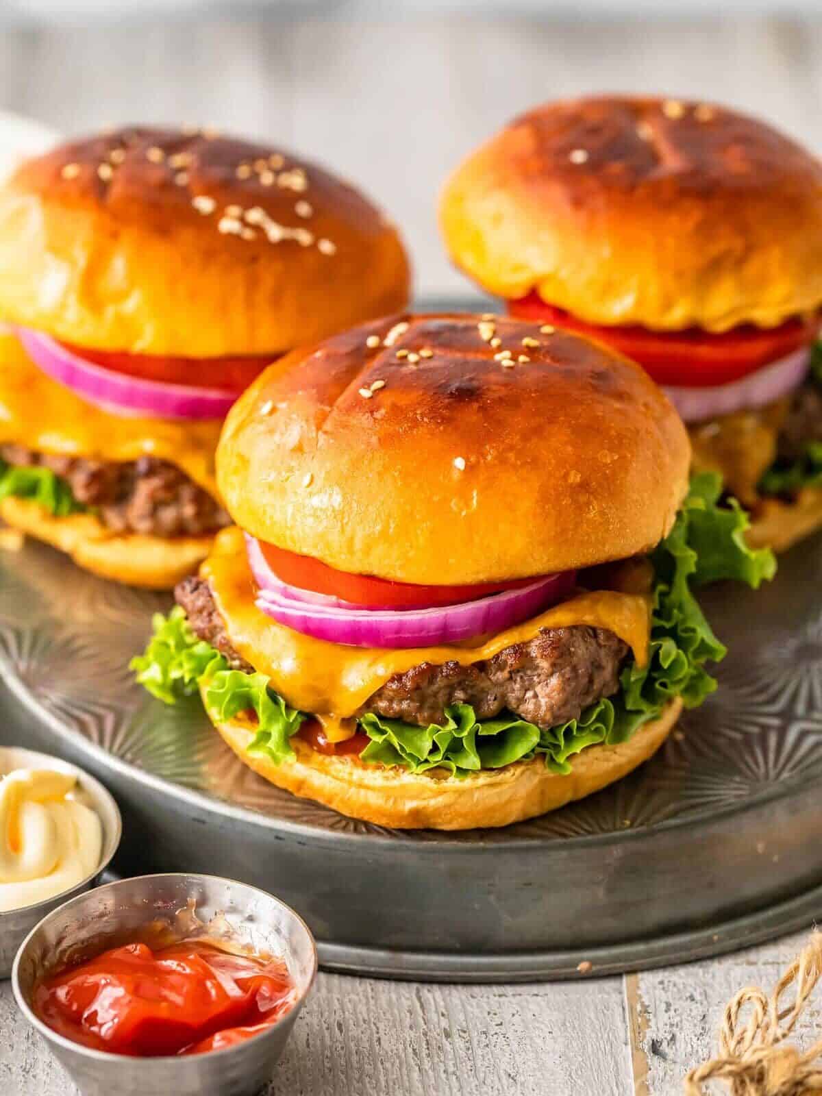 broiled hamburgers on buns with cheese and toppings