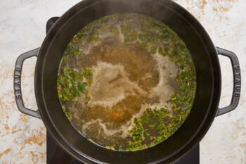 herbs and stock simmering in a Dutch oven.