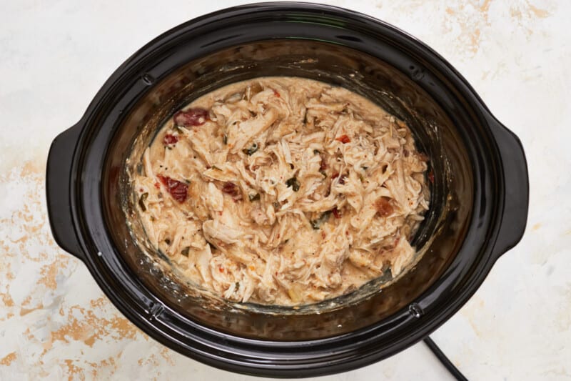 shredded crockpot alfredo chicken in a crockpot.