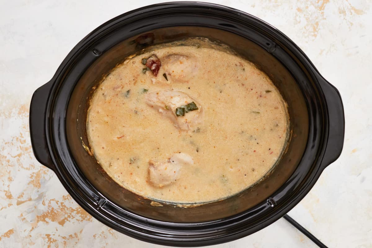 cooked alfredo chicken in a crockpot.