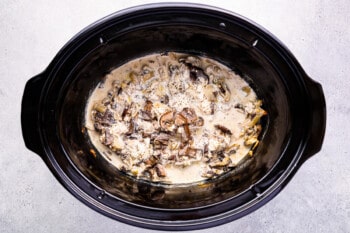 a black crock pot filled with mushrooms.