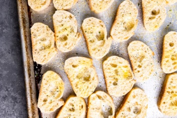 oiled and salted slices of french bread on a baking sheet.