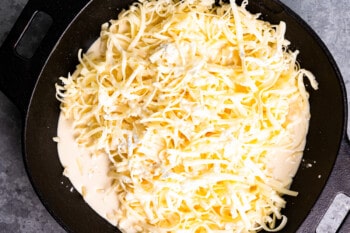 evaporated milk poured over shredded cheese and cornstarch in a pot.