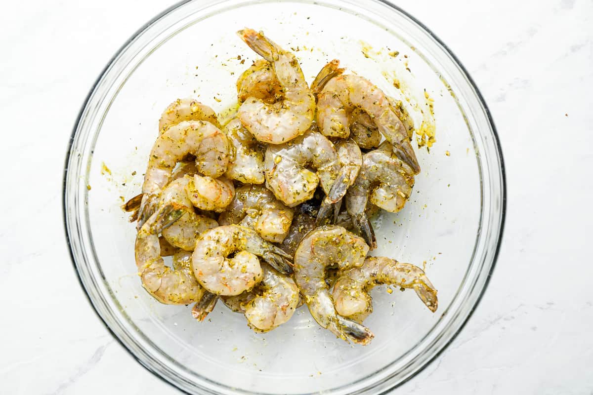 seasoned raw shrimp in a glass bowl.