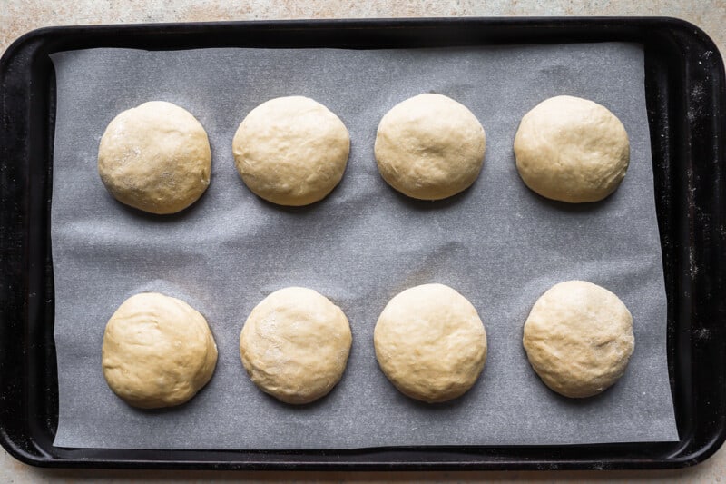 six dough balls on a baking sheet.