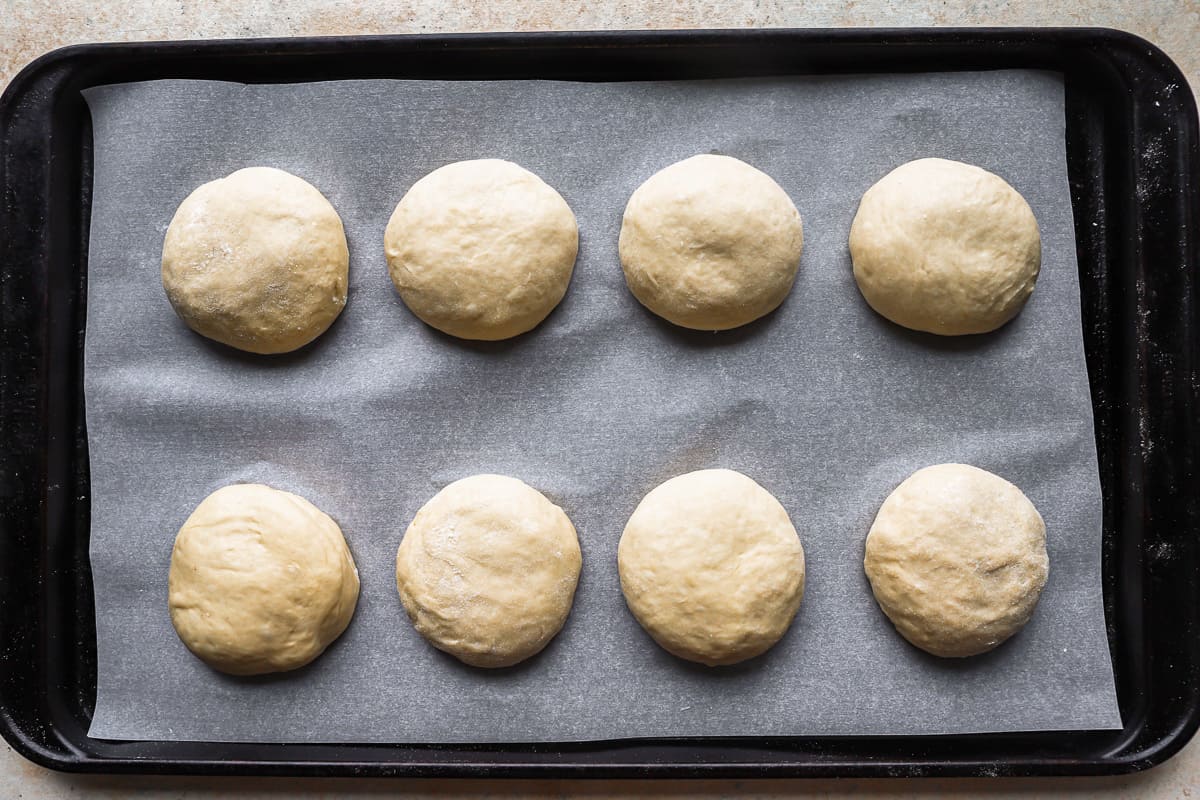 six dough balls on a baking sheet.
