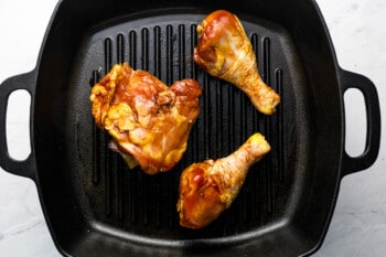 3 pieces of chicken on a grill pan.
