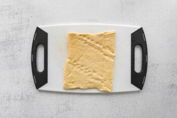 crescent dough on a plastic cutting board.