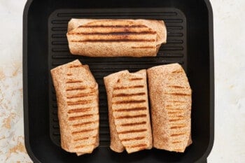 4 grilled chicken ranch wraps on a grill pan.