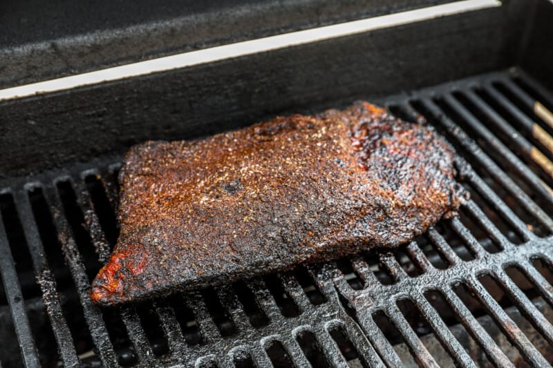 a piece of meat is being cooked on a grill.