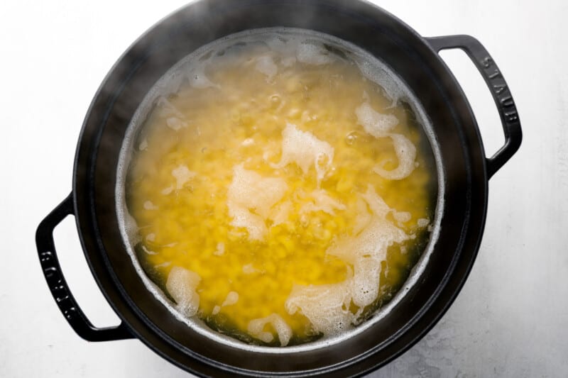 macaroni noodles boiling in a dutch oven.