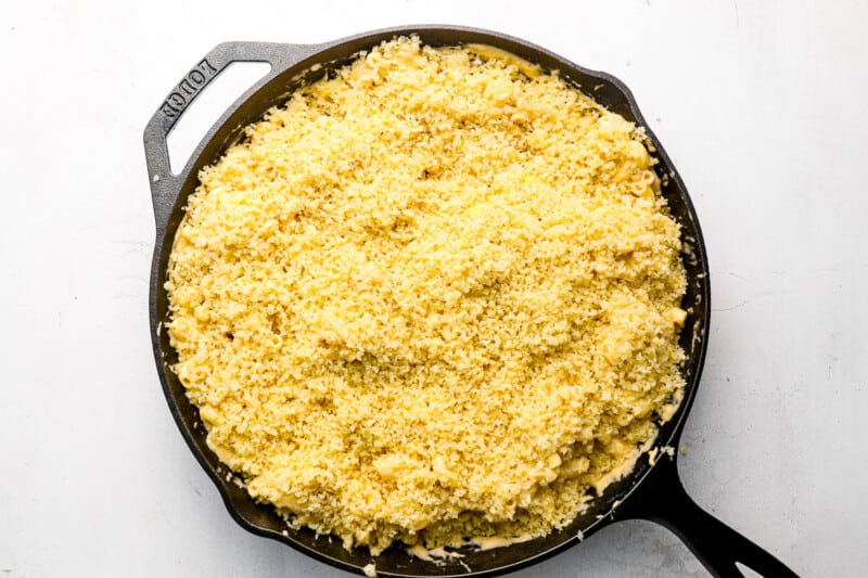 panko topping added to mac and cheese in a cast iron pan.