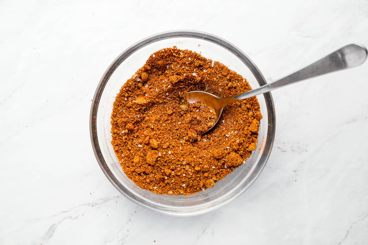 spice rub for pork chops in a glass bowl with a spoon.
