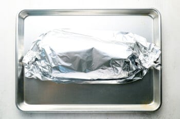 foil-wrapped pork loin on a baking sheet.