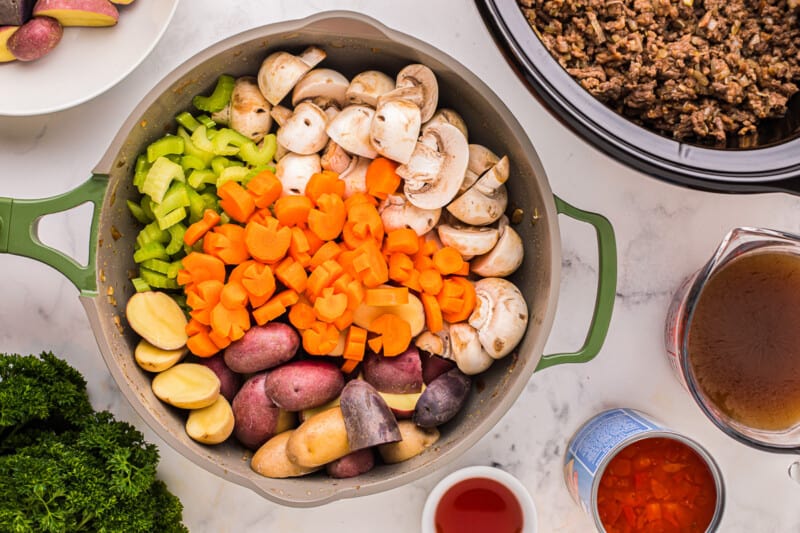 a crock pot full of vegetables and meat.