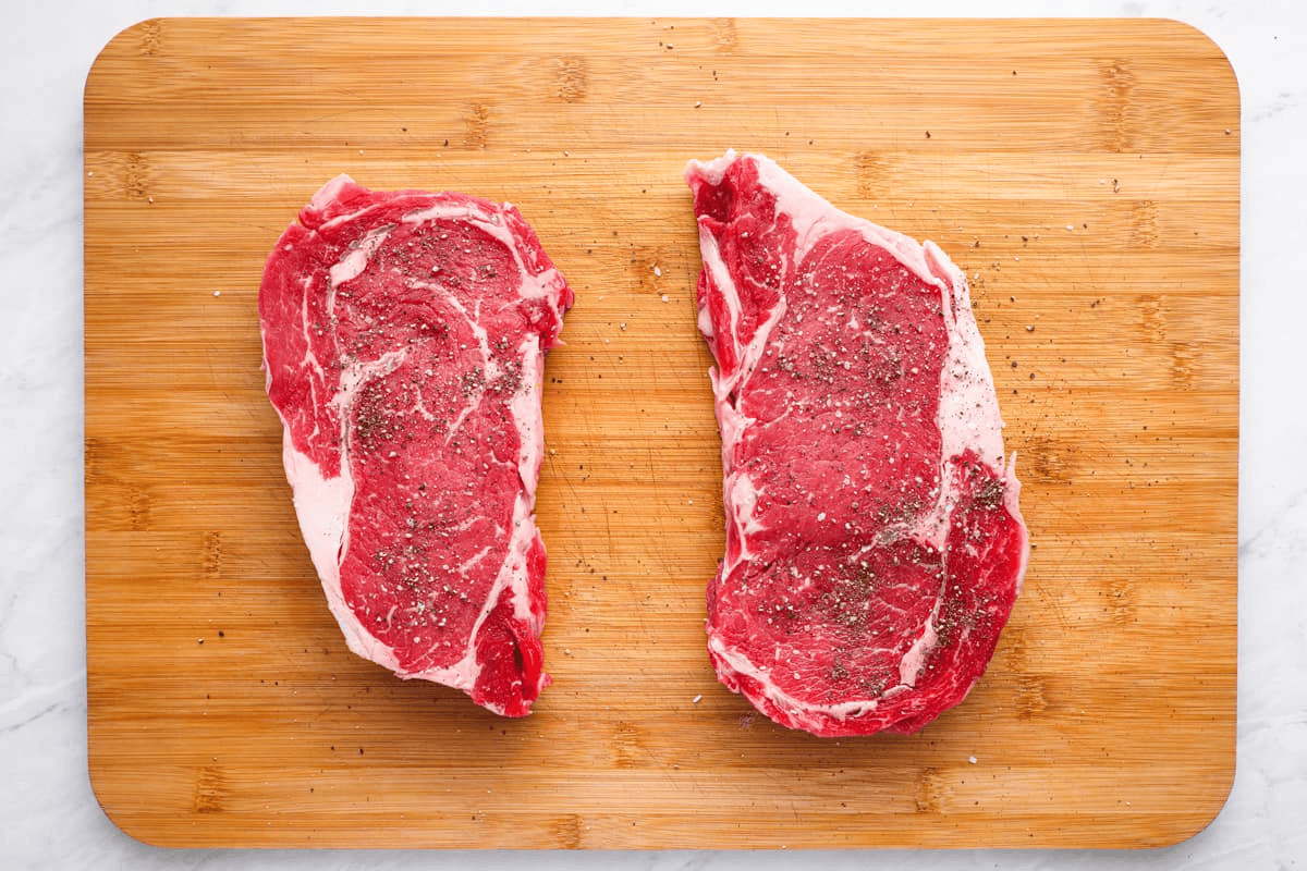Steaks seasoned with salt and pepper.