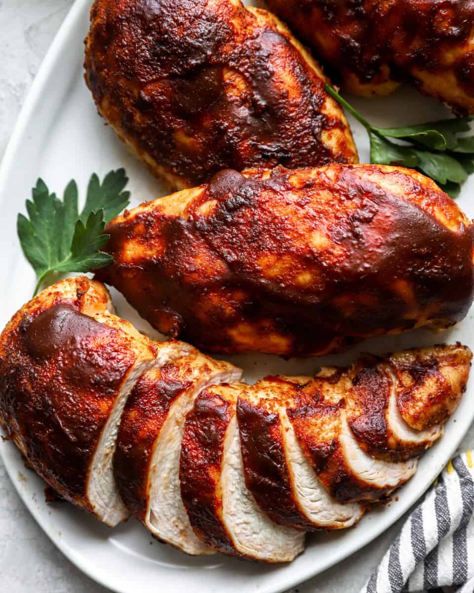 bbq chicken breasts on a white plate.