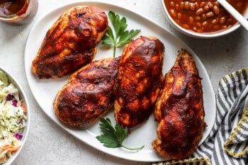 bbq chicken breasts on a plate with coleslaw.