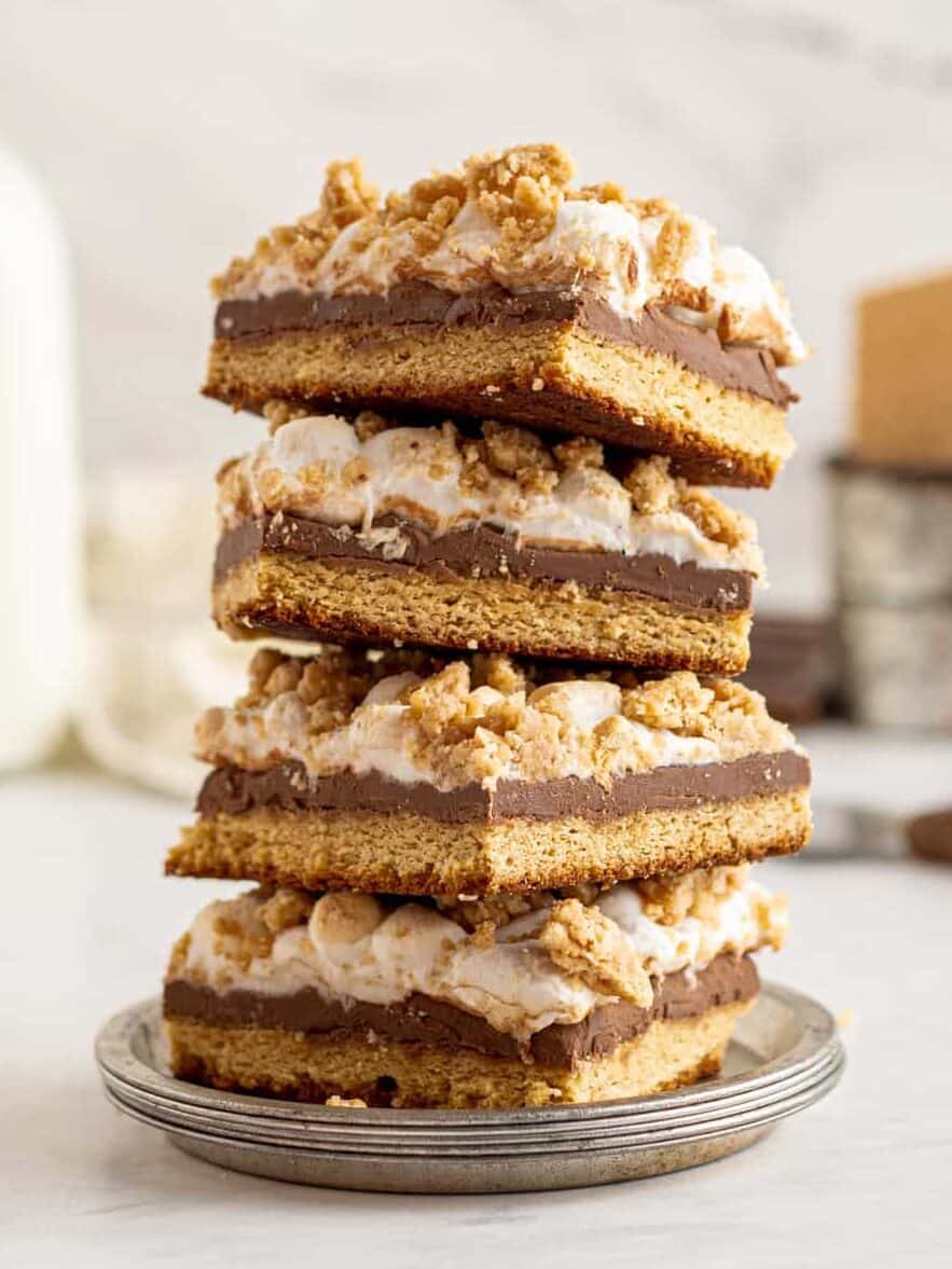 4 stacked smores bars with marshmallow topping on a small gray plate. 