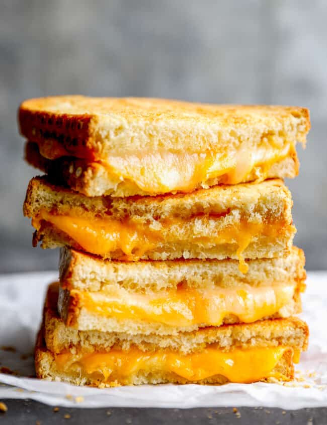 side view of 2 halved air fryer grilled cheese sandwiches stacked up to show the insides.