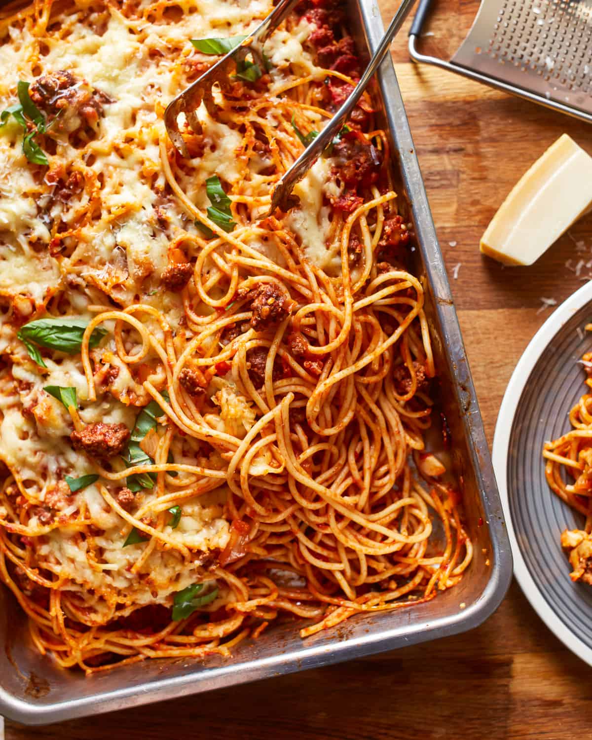 a dish of spaghetti and meatballs on a wooden table.