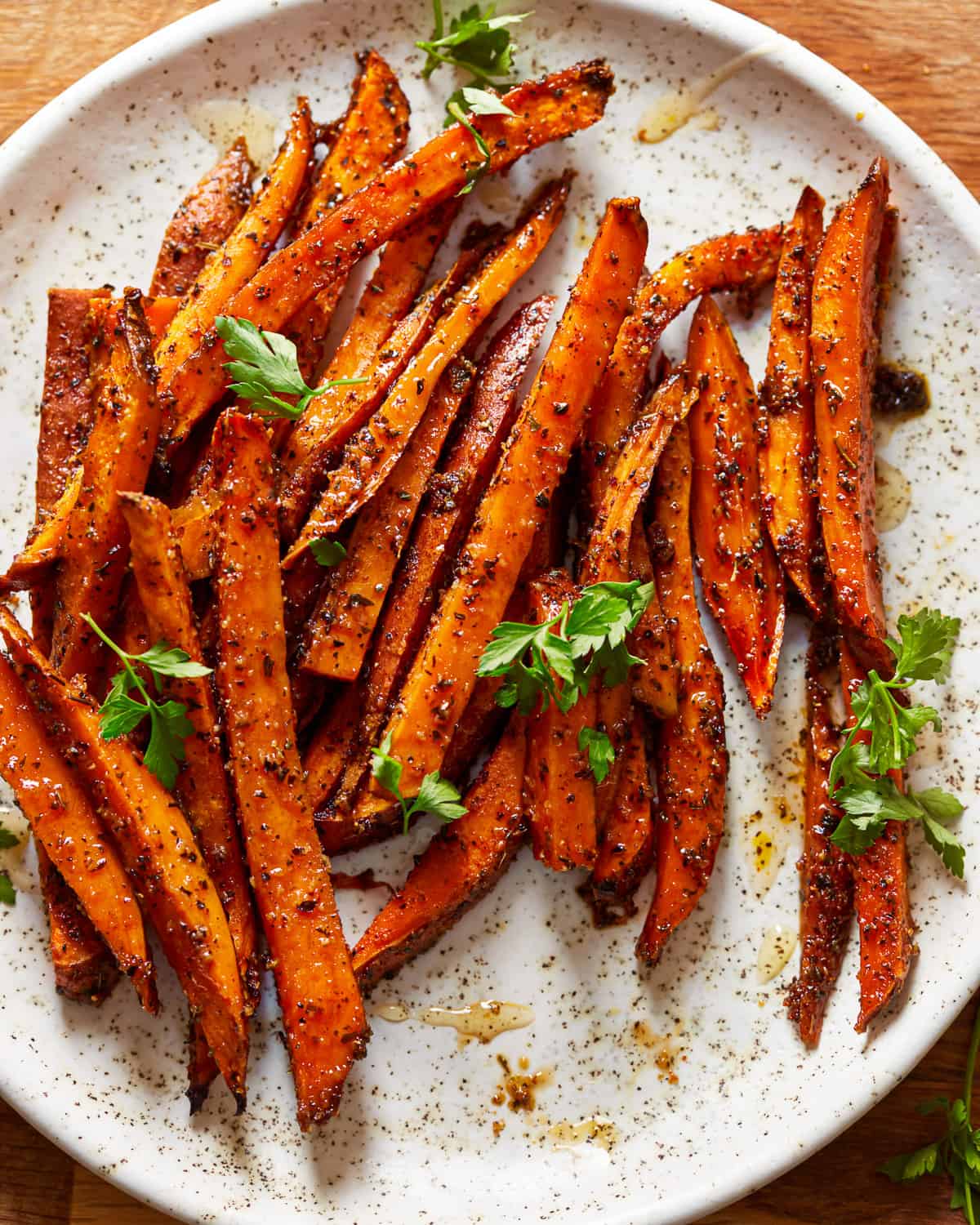 sweet potato fries on a plate with herbs.