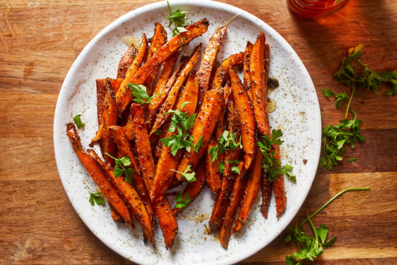 sweet potato fries on a plate with parsley.