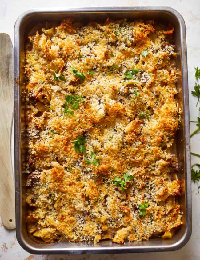 a baking dish filled with pasta and parmesan cheese.
