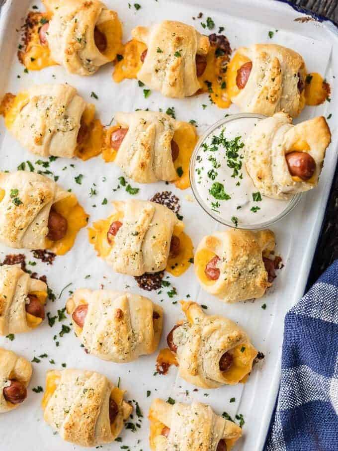 pigs in a blanket with cheese and ranch on a baking sheet