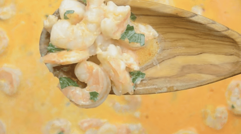 creamy garlic shrimp on a wooden spoon.