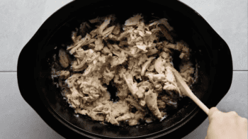 shredded chicken over cooked rice in a crockpot.