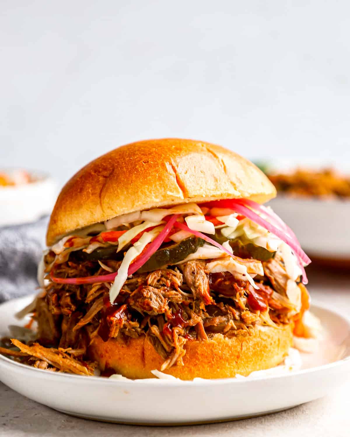 a Crockpot pulled pork sandwich on a plate with coleslaw.