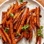 sweet potato fries on a plate with herbs.
