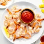 shrimp on ice with ketchup on a plate.