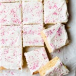 a sheet of white and pink frosted bars on a baking sheet.