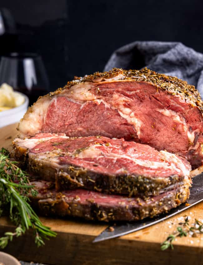 a piece of roast beef on a wooden cutting board.