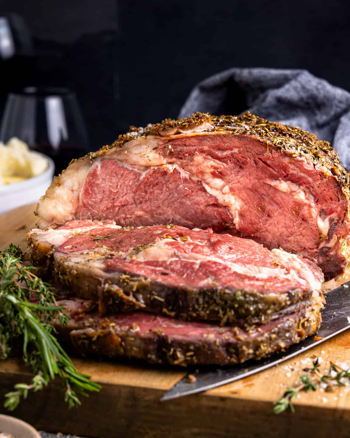 partially sliced prime rib on a wooden cutting board.