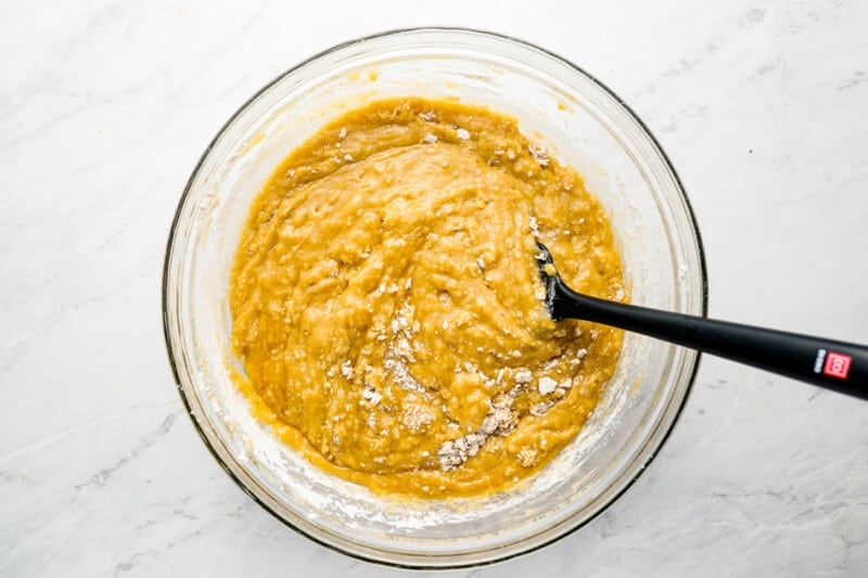 a bowl of batter with a black spatula in it.