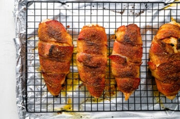 bacon wrapped chicken breasts on a cooling rack.