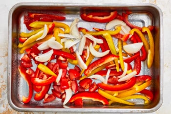 sliced peppers and onions in a baking pan.