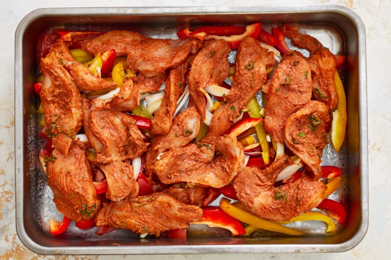 a baking pan filled with meat and peppers.