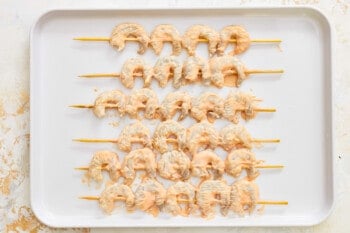 shrimp skewers on a white plate.