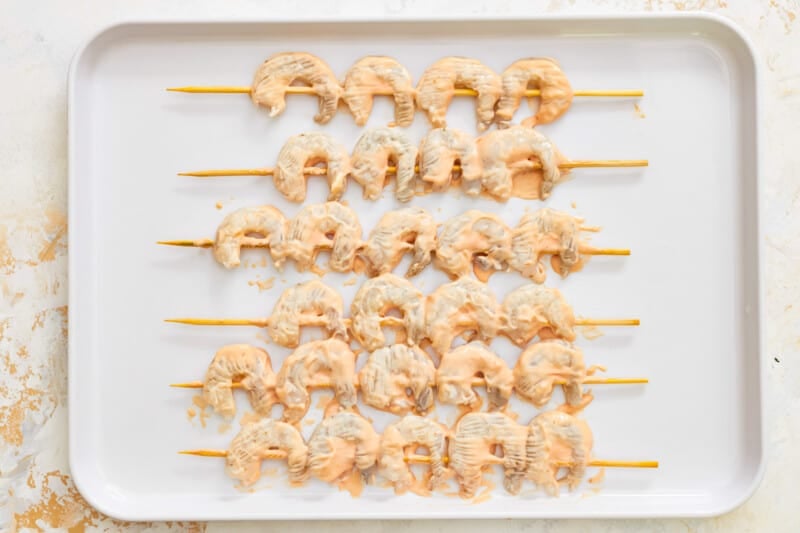 shrimp skewers on a white plate.